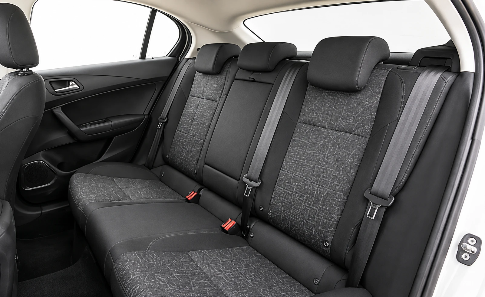 Asiento trasero del auto, con apoyacabezas y cinturones.